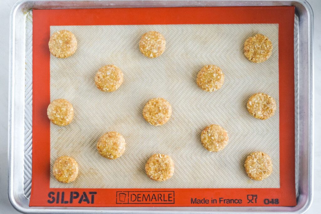formed anzac biscuits on a silpat baking mat, before baking.