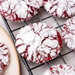 closeup of red velvet crinkle cookies on a cooling rack.