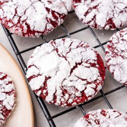closeup of red velvet crinkle cookies on a cooling rack.