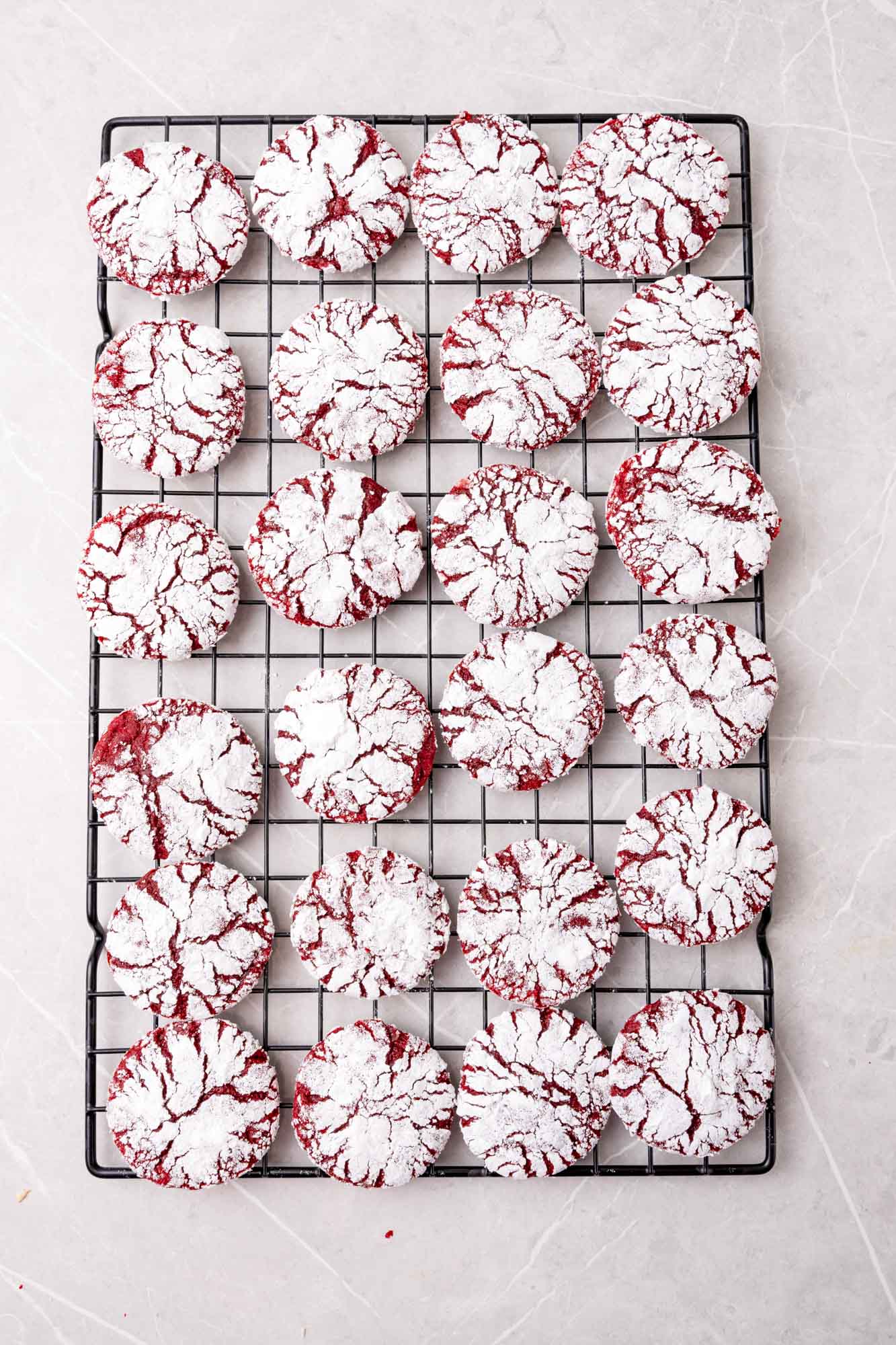 red velvet crinkle cookies on a rectangle cooling rack, viewed from overhead
