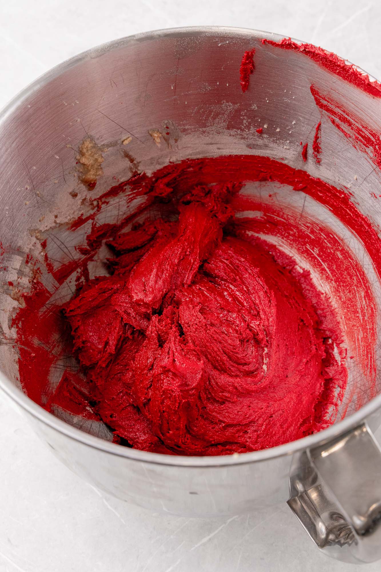 dough for red velvet crinkle cookies in a silver mixing bowl.