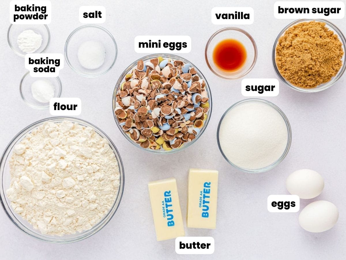 The ingredients for mini egg cookie bars, all in separate bowls, arranged on a counter.