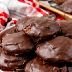 A plate of stacked texas sheet cake cookies with chocolate glaze.