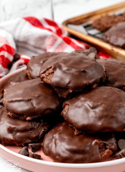 A plate of stacked texas sheet cake cookies with chocolate glaze.