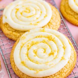 two large vanilla cookies with vanilla frosting swirls and golden oreo crumbs on top.