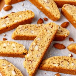 almond biscotti on a cutting board lined with parchment paper.