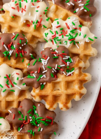 Soft, waffle shaped cookies. Each cookie is half dipped in either white or milk chocolate, and sprinkled with green, red, and white sprinkles.